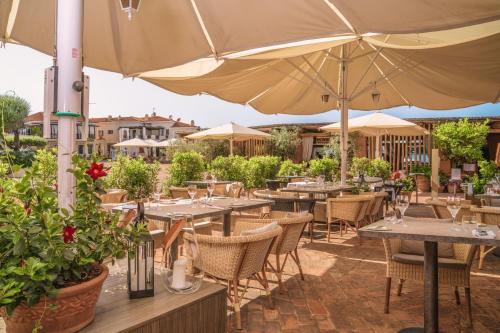 a restaurant with tables and umbrellas on a patio at Cervo Hotel,Costa Smeralda Resort in Porto Cervo