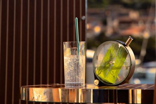 a glass of water and a clock on a table at Cervo Hotel,Costa Smeralda Resort in Porto Cervo