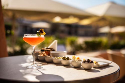 a drink sitting on a table with a tray of food at Cervo Hotel,Costa Smeralda Resort in Porto Cervo