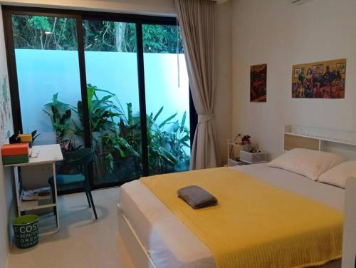 a bedroom with a bed and a desk and a window at Villa Chacha à Lamai in Lamai