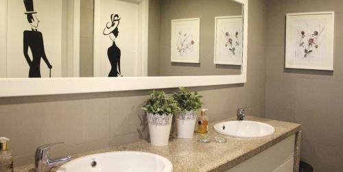 a bathroom with two sinks and a mirror at Monsanto GeoHotel Escola in Monsanto