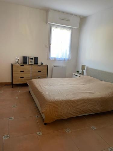 - une chambre avec un lit, une fenêtre et une commode dans l'établissement 2 pièces Saint Raphael rénové, classé 4 étoiles, 100 m plages, piscine, tennis, parc, terrasse, jardin privatif, à Saint-Raphaël