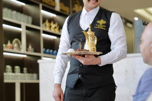 a man in a store holding a plate of food at Mora Hotel in Al Khobar