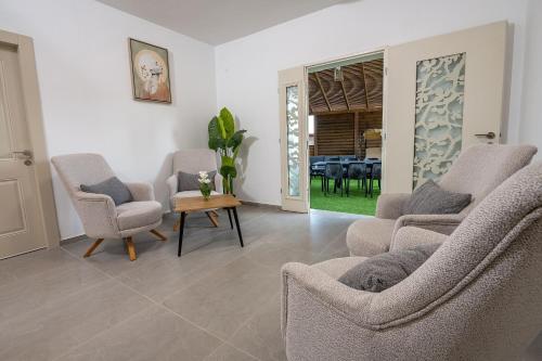 a living room with three chairs and a table at וילה קצה ההרים- וילה מדהימה עם בריכה פרטית מול נוף מהמם in ‘Ein el Asad