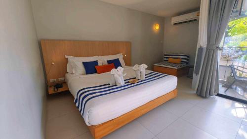 a bedroom with a bed with two stuffed animals on it at Casa De Mar - Koh Samui in Chaweng