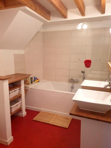 une salle de bain avec une baignoire blanche et un lavabo dans l'établissement Maison spacieuse Parc Régional Naturel Normandie, à Quevillon