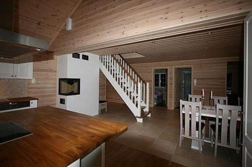 a kitchen and dining room with a table and chairs at Flott utleiehytte på Gautefall in Treungen