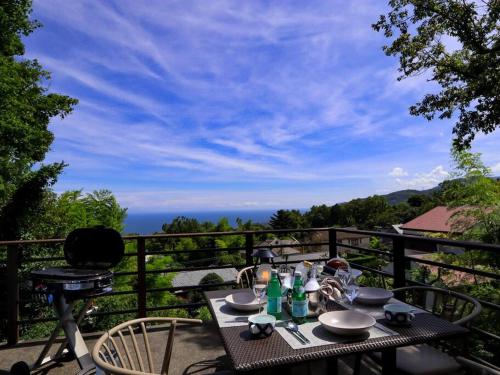 a table and chairs on a balcony with a view at 伊豆高原-忘我庵 Cozy Ocean View Villa in Ito