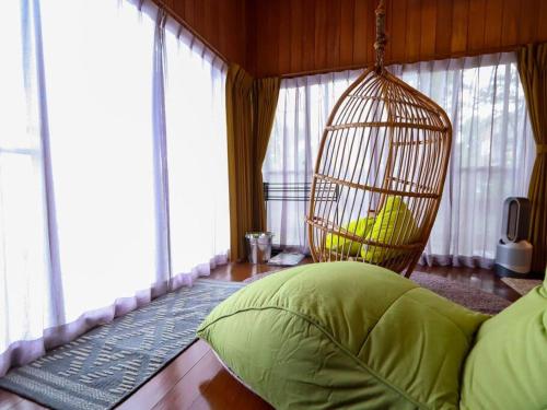 a room with a bird cage and a bed at 伊豆高原-忘我庵 Cozy Ocean View Villa in Ito