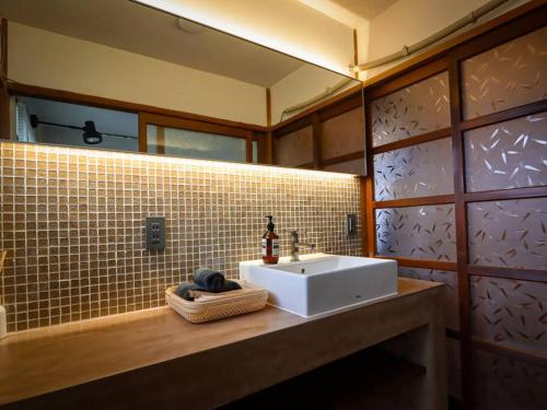 a bathroom with a white sink and a mirror at 伊豆高原-忘我庵 Cozy Ocean View Villa in Ito