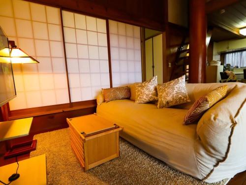 a living room with a couch with pillows on it at 伊豆高原-忘我庵 Cozy Ocean View Villa in Ito
