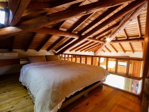 a bedroom with a bed in a room with wooden floors at 伊豆高原-忘我庵 Cozy Ocean View Villa in Ito