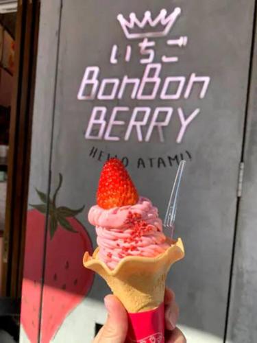 a person holding a strawberry ice cream cone with a fork at 伊豆高原-忘我庵 Cozy Ocean View Villa in Ito