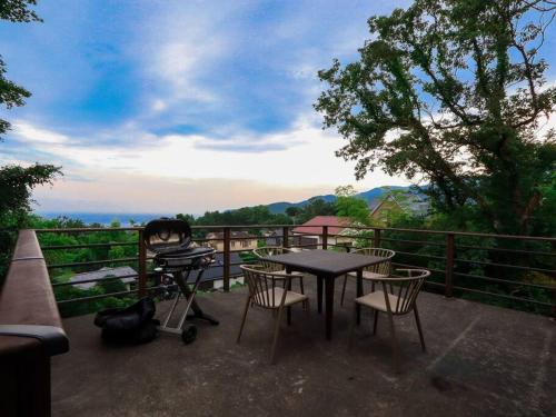 a patio with a table and chairs and a grill at 伊豆高原-忘我庵 Cozy Ocean View Villa in Ito