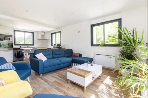 un salon avec un canapé bleu et une table dans l'établissement Maison contemporaine aux portes de Brest, à Bohars