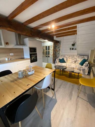 Il dispose d'une cuisine et d'un salon avec une table et des chaises en bois. dans l'établissement Jolie maison de campagne à la ville chez TINAT, à Trégueux