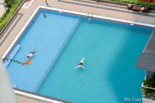 two people swimming in a large swimming pool at 2BR Luxury riverview - Melody of the Sea Monarchy in Da Nang