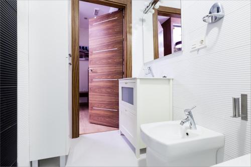 a bathroom with a sink and a toilet and a door at Hostal Arriola in Granada