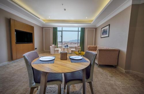 a living room with a wooden table and chairs at Suknai Royal Hotel in Hail