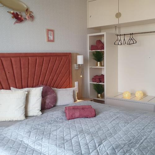 une chambre avec un grand lit avec une tête de lit rouge dans l'établissement Bel Mare resort ekskluzywny apartament dla wymagających klientów 2, à Międzyzdroje