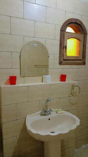 a bathroom with a sink and a mirror at White Desert Soul Safari Camp Desert Experience in Mandīshah