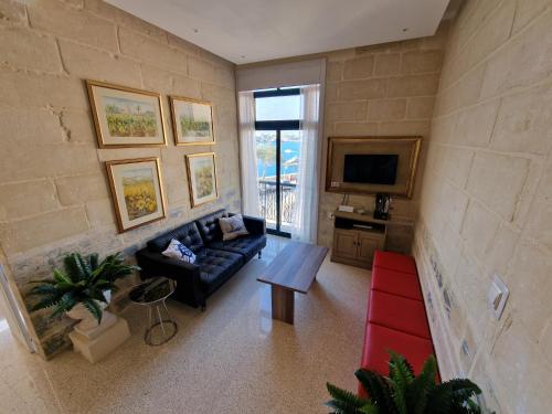 ein Wohnzimmer mit Couch und Fernseher in der Unterkunft Grand Harbour View in Valletta