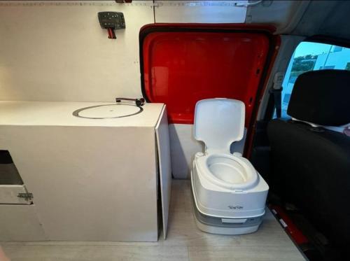 Un inodoro blanco en la parte trasera de una casa rodante. en Surf & love, en Cabanas de Tavira