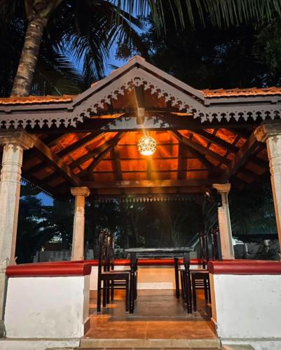 un restaurante con mesa y sillas en un pabellón en HOME STAY at SRIRAM VILLA Kumbakonam, en Kumbakonam