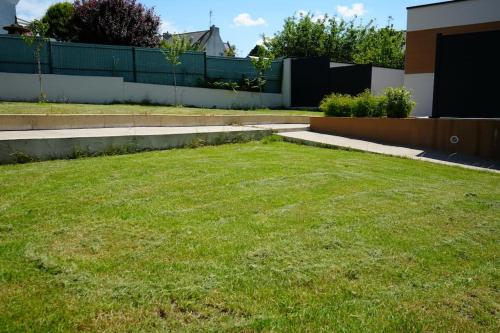 a yard with a grassy yard with a fence at Suite parentale à 1 min du parc des expositions in Bohars