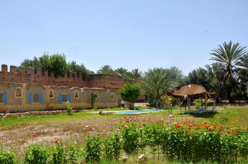 un vecchio edificio con un campo di fiori di BIVOUAC Sous Les Palmiers Bleus a Ouijjane