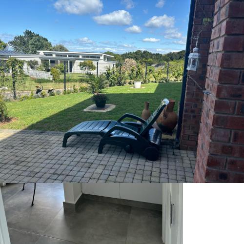 a bench sitting on a patio with a yard at Loerie Lane Accomadation in Groot Brak Rivier