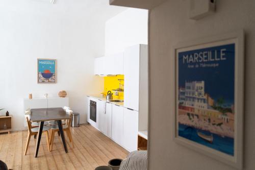 une cuisine avec une table et une salle à manger dans l'établissement JULIEN - Gare St Charles - Cours Julien, à Marseille
