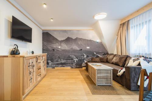 a living room with a couch and a tv at Panocek i Babka in Białka Tatrzanska