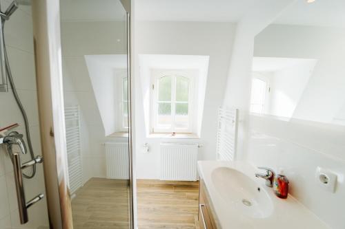 une salle de bain blanche avec un lavabo et une douche dans l'établissement Villa Levin 35qm 2Personen mit Pool Wifi und Parken, à Steudnitz