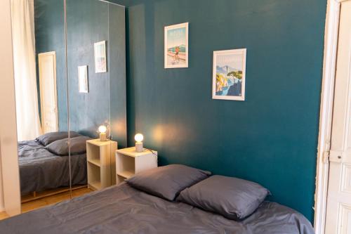 - une chambre avec un miroir et 2 lits dans l'établissement JULIEN - Gare St Charles - Cours Julien, à Marseille