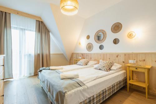 a bedroom with two beds and a table and a window at Panocek i Babka in Białka Tatrzanska