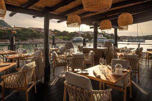 a restaurant with tables and chairs with a view of the water at Cervo Hotel,Costa Smeralda Resort in Porto Cervo