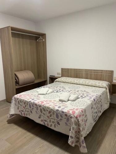 a bedroom with a bed with a pink and white blanket at Apartamentos 7 puentes sierra Cazorla Casa Ciprés in Burunchel
