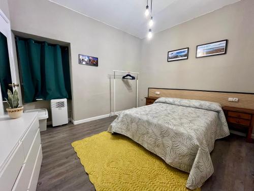 a bedroom with a bed and a yellow rug at El Capricho Vasco-Andaluz in El Puerto de Santa María