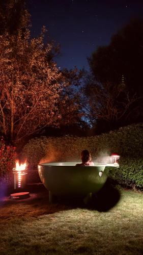 a person in a bathtub in a yard at night at House W - North Sea Stays in De Haan