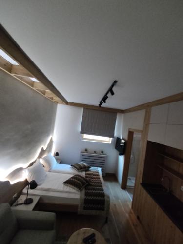 a bedroom with a bed and a couch at Apartments D035 & D032 in Aparthotel Vucko, Jahorina-private host in Jahorina