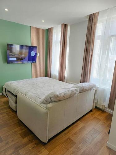 - une chambre avec un lit blanc dans une pièce dotée de fenêtres dans l'établissement Élégant T2 au cœur de Cambrai, à Cambrai