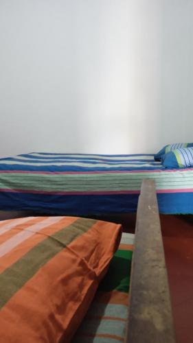 a bed with multicolored sheets on top of it at Sithumina Holiday Home in Diyatalawa