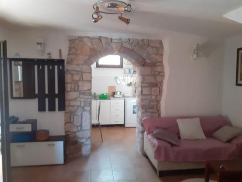 ein Wohnzimmer mit einem roten Sofa und einem steinernen Torbogen in der Unterkunft Casa Agneza in Medulin