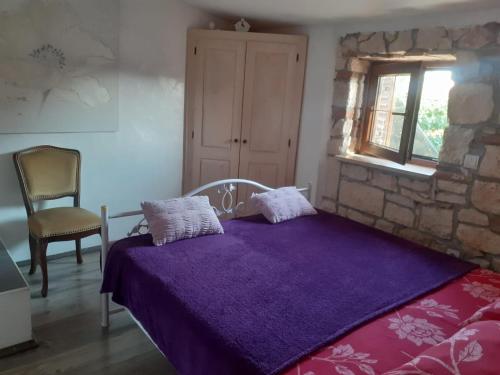 ein Schlafzimmer mit einem lila Bett und einem Fenster in der Unterkunft Casa Agneza in Medulin