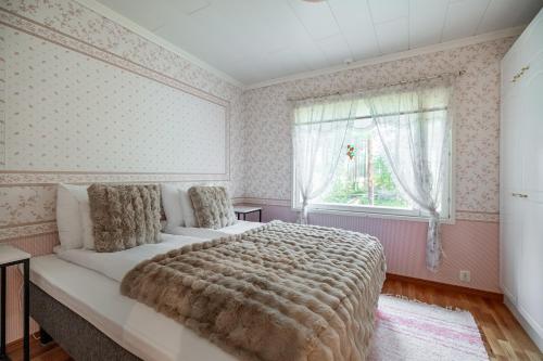 a bedroom with a large bed and a window at Arctic Countryside House in Rovaniemi