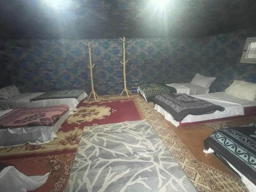 a room with four beds in a tent at Merzouga Camel Trekking Camp in Merzouga