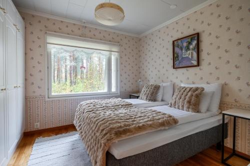 a bedroom with a large bed and a window at Arctic Countryside House in Rovaniemi