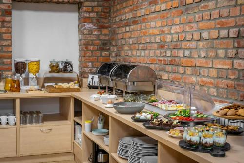 eine Küche mit einem Buffet und einer Ziegelwand in der Unterkunft Aparthotel Platinum in Stettin