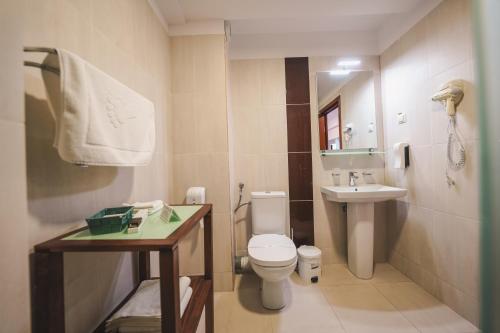 a small bathroom with a toilet and a sink at Hotel Marea Neagra in Sinaia